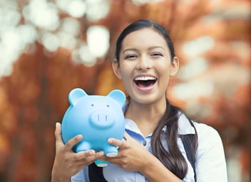 Closeup portrait happy, smiling business woman, bank employee holding piggy bank, isolated outdoors indian autumn background. Financial savings, banking concept. Positive emotions, face expressions